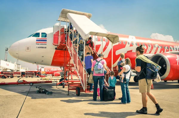 BANGKOK, THAILAND - 8 FEBRUARY, 2014: international tourist people boarding on Air Asian airplane boeing 737 in Don Muang Airport, the main hub specialized in internal flights and lowcost companies