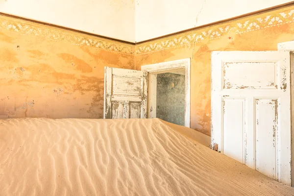 Abandoned house full of sand from the desert in the ghost town of Kolmanskop - Sightseeing around Luderitz in Namibia - African wonders and mysteries