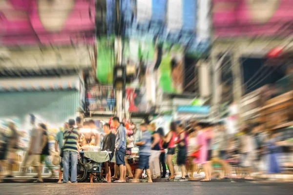 People on the road in Bangkok nightlife - International tourists and thai asian locals on walking street at night hours in thailand urban area - Image edited with radial zoom defocusing