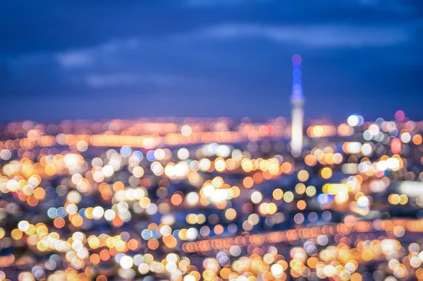 Bokeh of Auckland skyline from Mount Eden after sunset during the blue hour - New Zealand modern city with spectacular nightscape panorama - Blurred defocused night lights