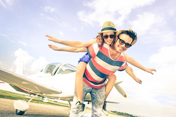 Happy hipster couple in love on airplane travel honeymoon vacation - Summer concept with male and female models at exclusive trip excursion - Best friends having fun - Bright vintage filtered look