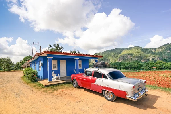 VAL VINALES, CUBA - NOVEMBER 20, 2015: vintage car Chevrolet Bel Air parked at farmer bungalow in the country side of Cuba in the province of Pinar del Rio - Warm afternoon color tones