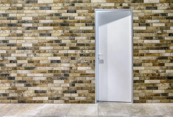 A white plastic door and the artificially aged brick wall