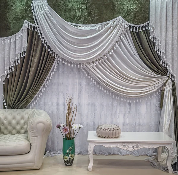 An interior design in the green and white colors. Contrasting curtains with the pelmet and light translucent tulle.