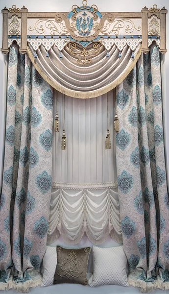 A window and a wall in the palace style. The combination of French curtains with drapes. Soft and Hard pelmet with the applique.