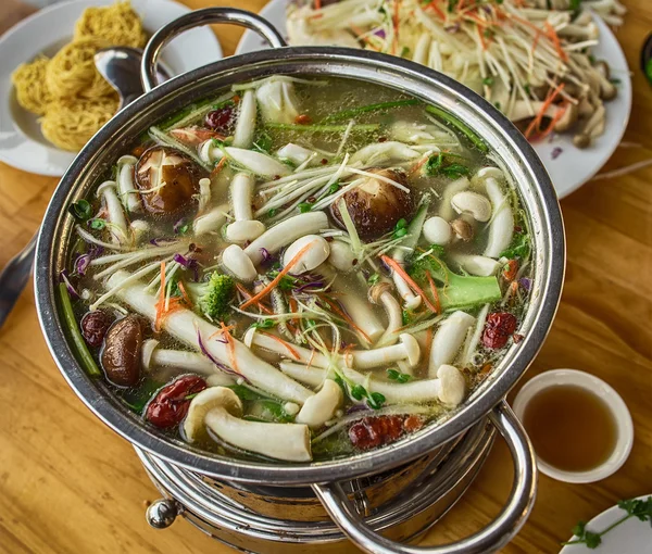 A cooking Vietnamese, Asian food in the cafe and restaurant on the dining table. Mushrooms and seafood cooked in a large pot on the fire