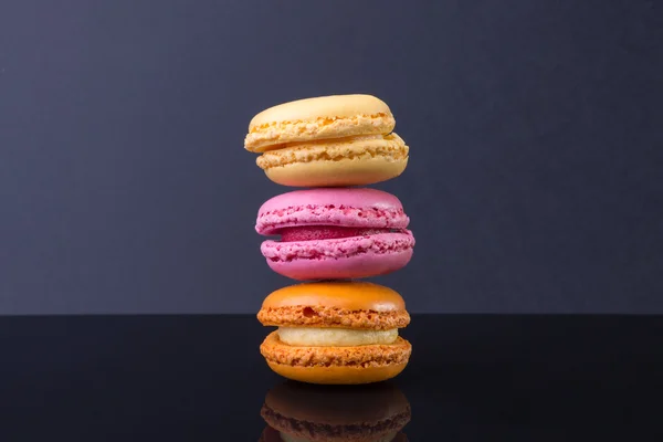Macarons.french small colored cookies on a black background