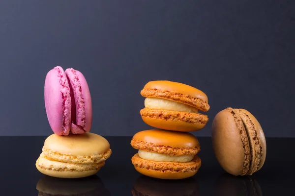 Macarons.French small colored cookies on a black background