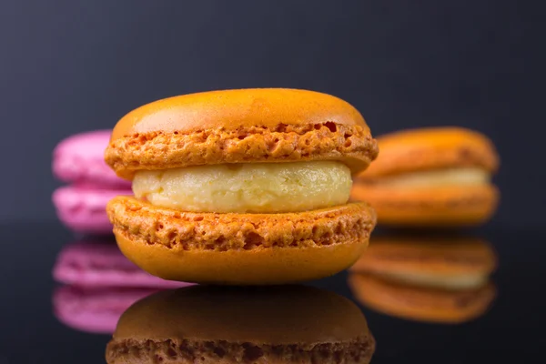 Macarons.French small colored cookies on a black background