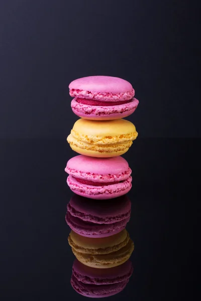 Macarons.French small colored cookies on a black background