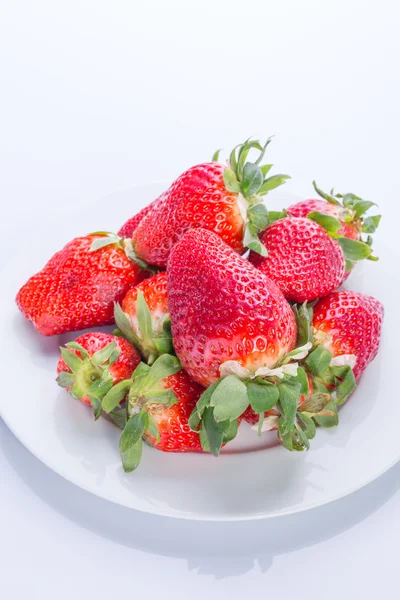 Strawberry red on a white plate and a white background, a bright image with contrast. side view, top. summer red berries. a series of color photographs