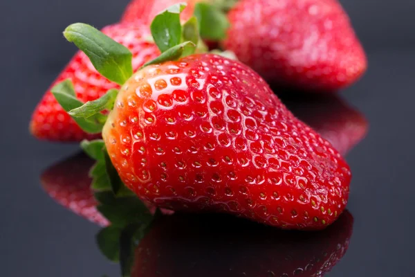 Big red strawberry on a black background, a contrast color image with space for text. sophisticated look berries.
