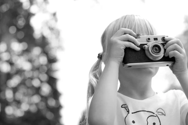 Little girl taking picture using vintage film camera