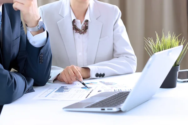 Business colleagues working and analyzing financial figures on a digital laptop