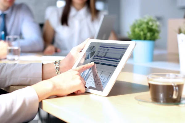 Business colleagues working together and analyzing financial figures on a digital tablet