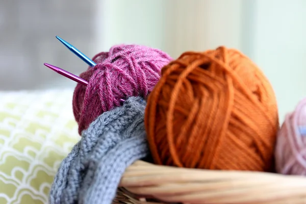 Knitting yarn balls and needles in basket