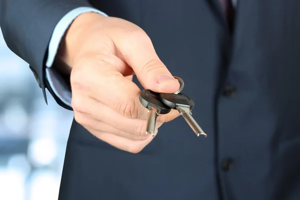 Cropped image of estate agent giving house keys in office