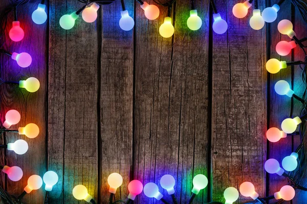 Frame Of Colorful Christmas lights Bulb On Wood
