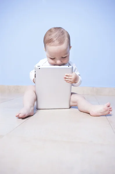 Sitting baby boy discovering tablet pc