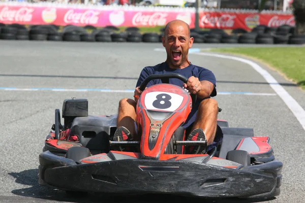 Man having fun on a go cart. Scary face