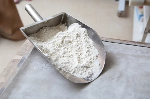 Metal scoop full of flour