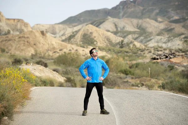 Sport man runner posing on dry desert landscape in fitness healthy lifestyle