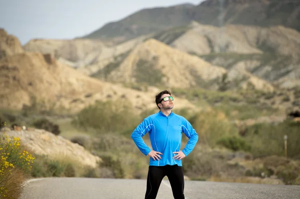 Sport man runner posing on dry desert landscape in fitness healthy lifestyle