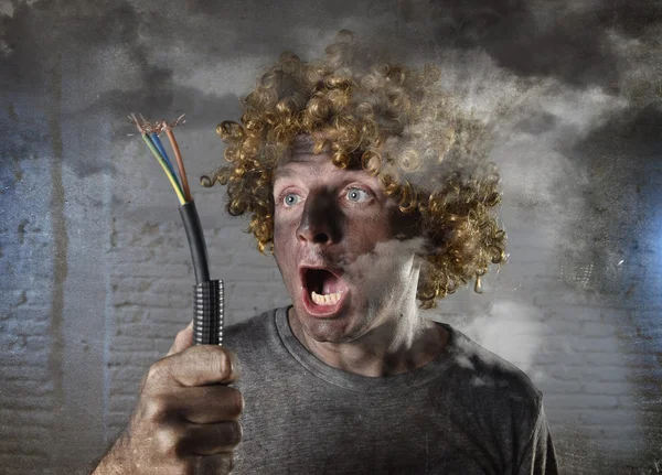 Man with cable smoking after domestic accident with dirty burnt face shock electrocuted expression