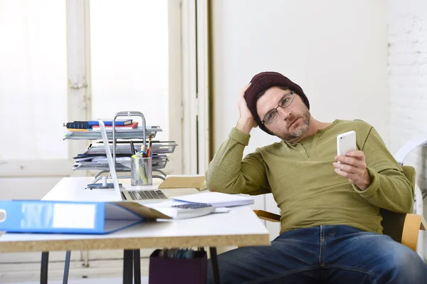 Young attractive hipster businessman working from his home office as freelancer self employed business model