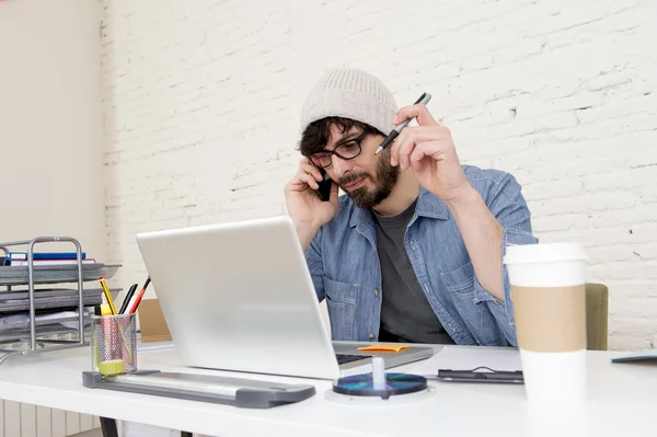 hispanic attractive hipster businessman working at home office talking on mobile phone