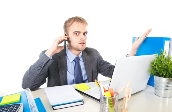 Young businessman worried tired talking on mobile phone in office suffering stress