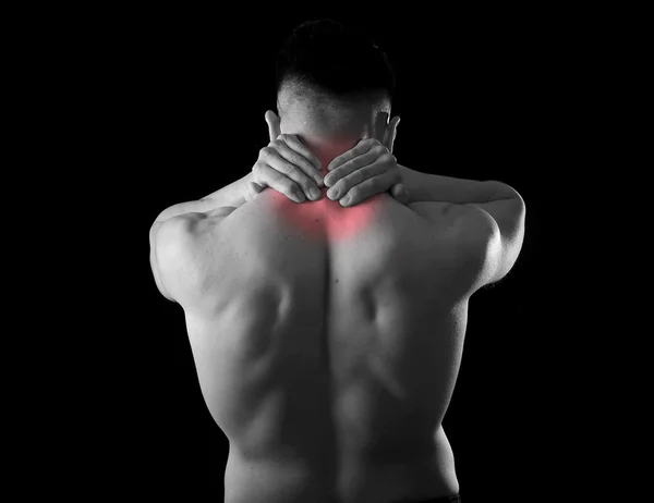 Back young muscular sport man holding sore neck touching massaging cervical area