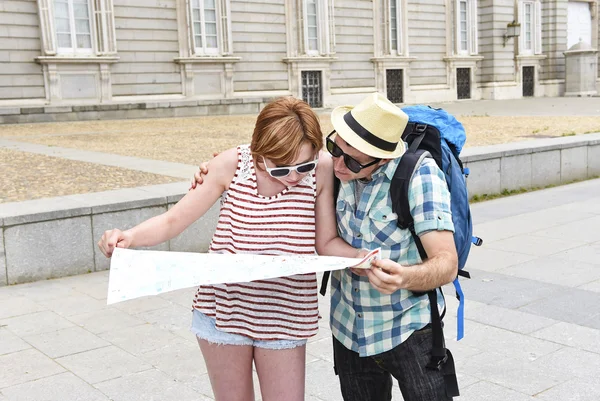 Young tourist couple visiting Madrid in Spain lost and confused loosing orientation