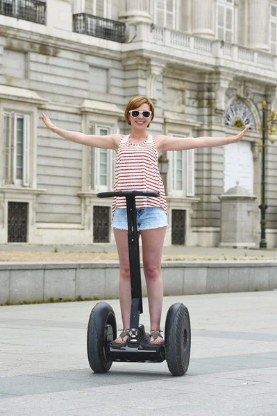 Young attractive tourist woman in shorts city tour riding happy electrical segway in Spain