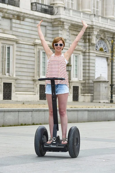 Young attractive tourist woman in shorts city tour riding happy electrical segway in Spain
