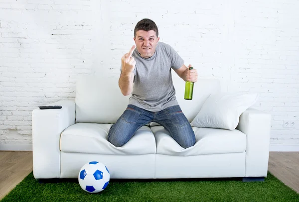 Angry football fanatic fan watching game on television at home couch gesturing upset