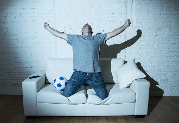 crazy football fan watching tv soccer match alone screaming happy celebrating goal