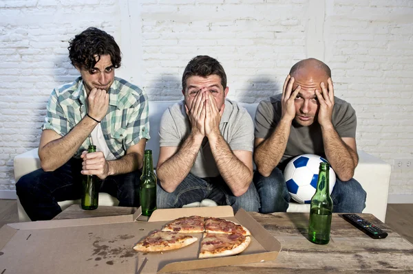Friends fanatic football fans watching tv match with beer bottles and pizza suffering stress