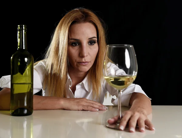 Drunk alcoholic blond woman in wasted depressed face looking thoughtful to white wine glass