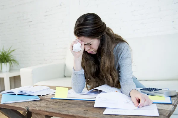 Young worried woman suffering stress doing domestic accounting paperwork bills