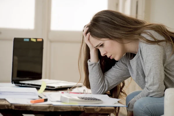 Worried woman suffering stress doing domestic accounting paperwork bills and invoices
