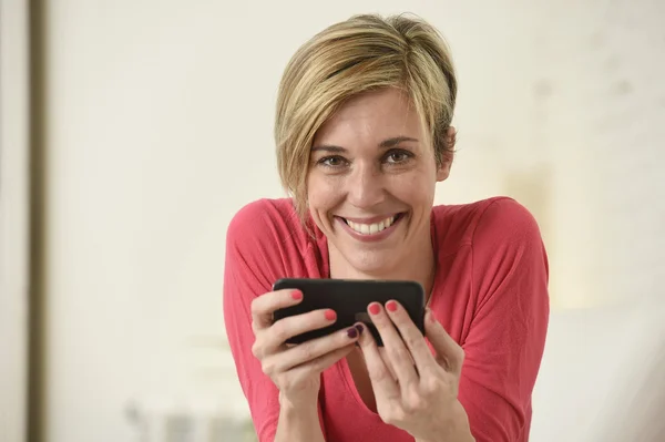 Young beautiful Caucasian woman happy using internet app on mobile phone smiling happy