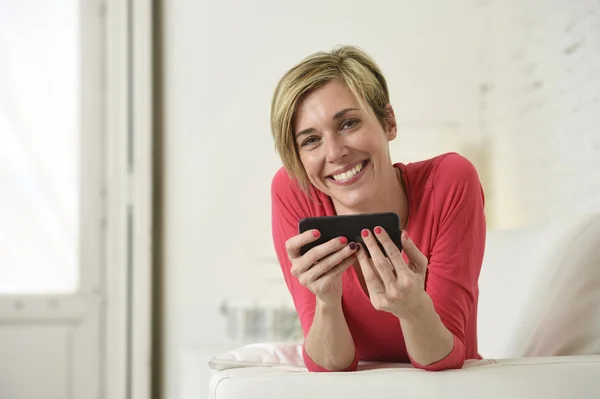 Young beautiful Caucasian woman happy using internet app on mobile phone smiling happy
