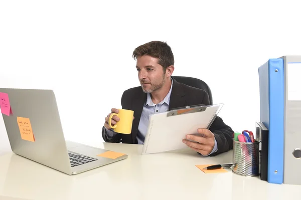 Young attractive businessman working happy confident at office reading file drinking coffee