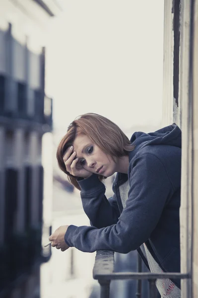 Young woman suffering depression and stress outdoors at the balcony
