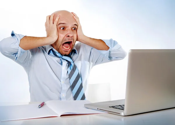 Hispanic overworked frustrated businessman on tie screaming in stress at computer laptop