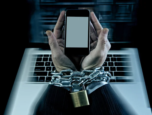 Hands of businessman addicted to work locked and enchained in mobile phone addiction