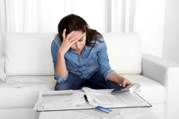 Young woman worried at home in stress accounting bank papers with calculator