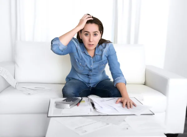 Young woman worried at home in stress accounting bank papers with calculator