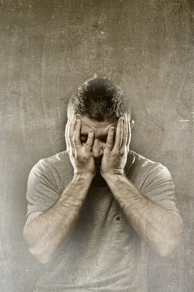 Man suffering depression, headache ,migraine and pain covering face with hands